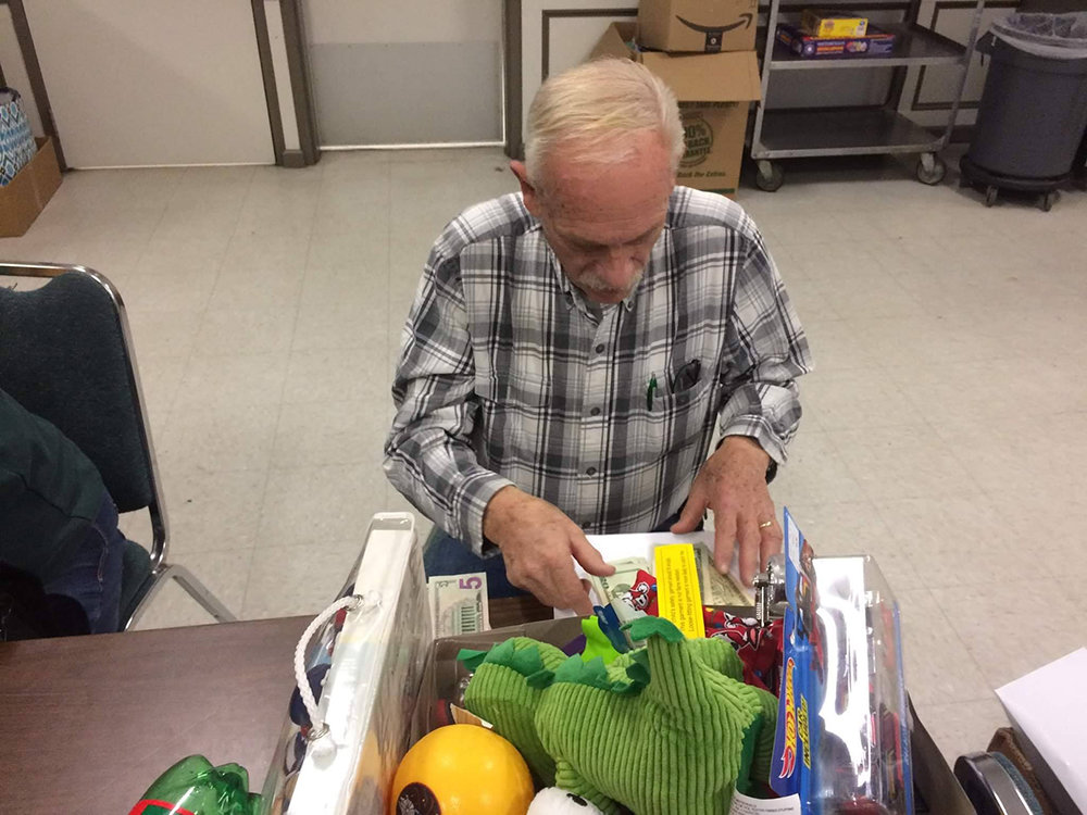 Rev. Jim Van Houten helps prepare some gift packages at the Walden Fire House.