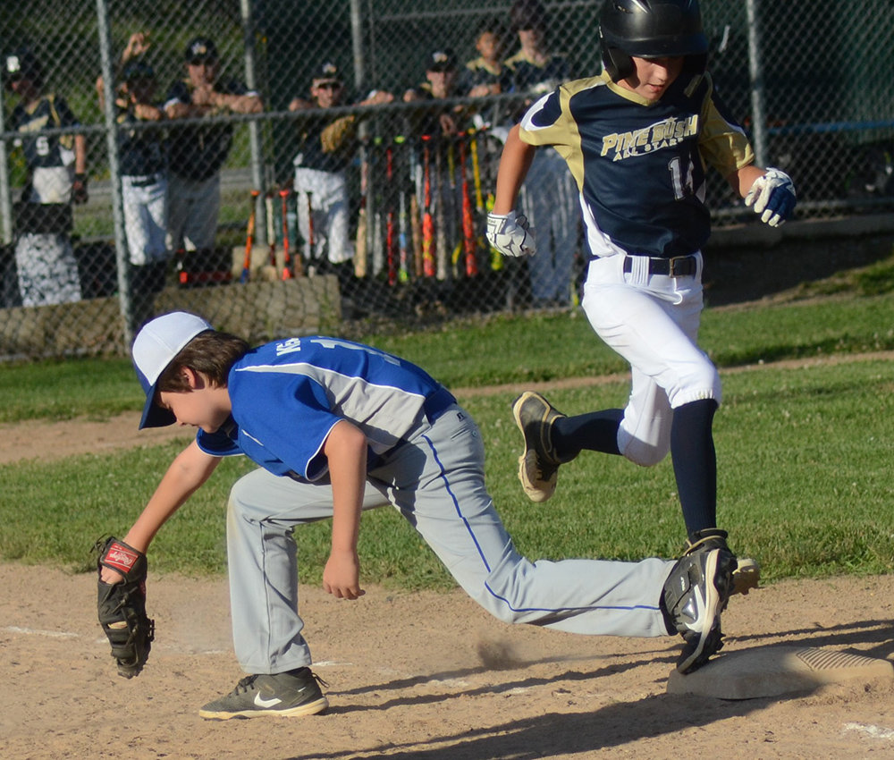 Pine Bush’s Easton Vellenga is out at first base as Town of Newburgh-New Windsor’s Liam Keller takes the throw during Wednesday’s District 19 Major baseball game at Goshen Little League.