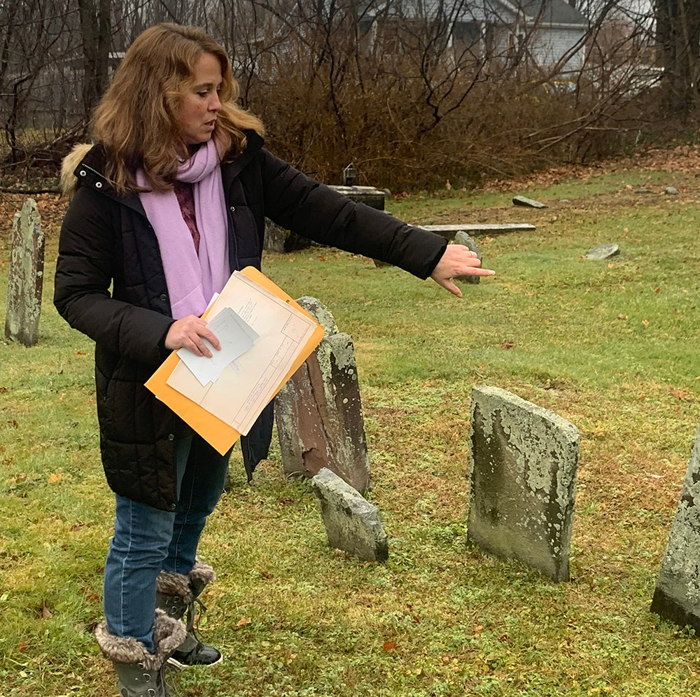 Plattekill Town Historian Libby Werlau examines tombstones in a cemetery that borders the Plattekill Corners General Store.