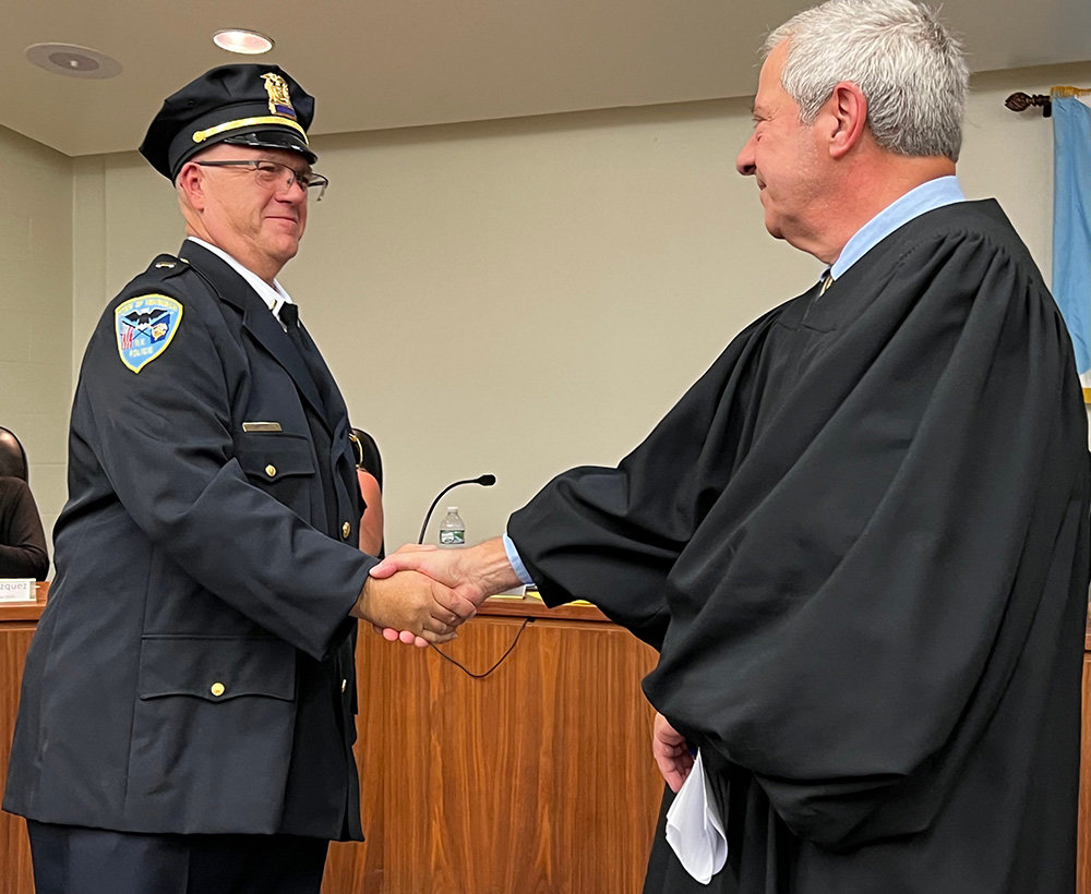 [L-R] Dennis Carpenter is promoted to the rank of lieutenant within the Town of Newburgh Police Department and shakes hands with Town Justice Richard Clarino.