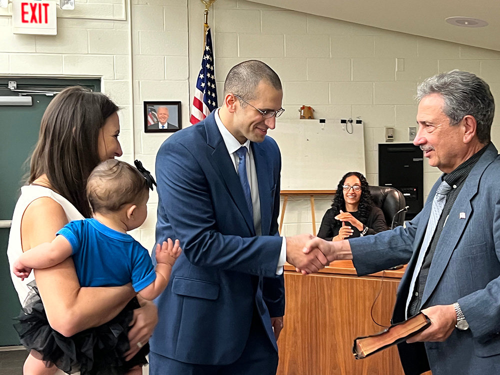 [L-R] Alexis and Ella Fiordalis joined newest member of the Town of Newburgh Police Department William Fiordalis for his official swearing in. William shakes hands with Town Supervisor Gil Piaquaido following the reciting of the oath of office.