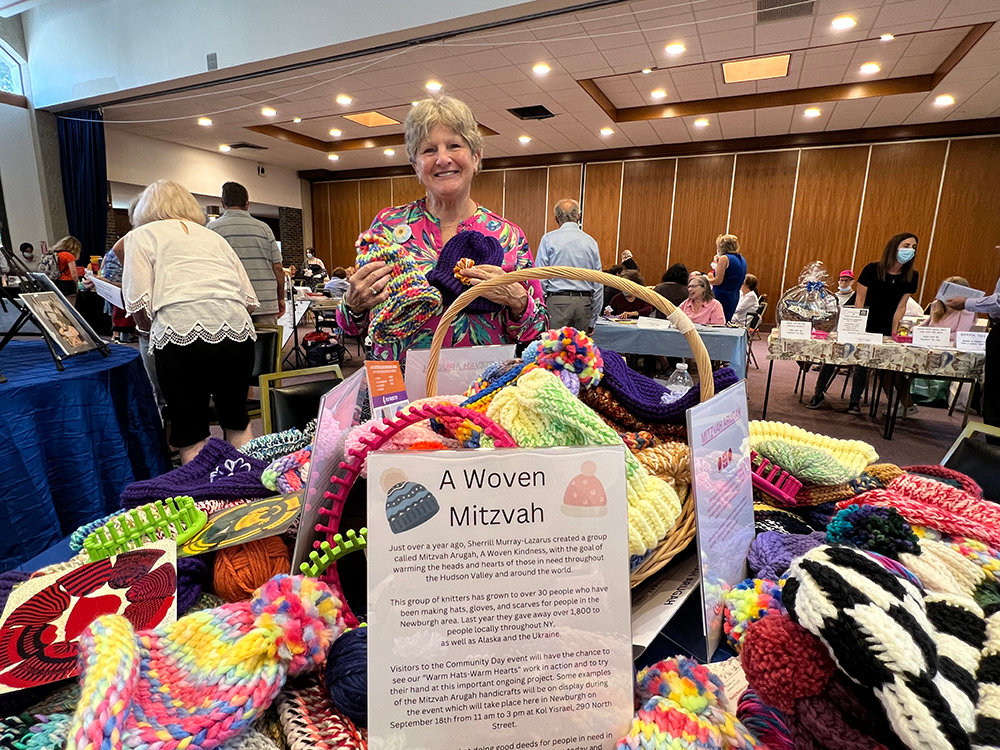 Sherrill Murray-Lazarus, creator of Mitzvah Arugah, A Woven Kindness, happily displays several hand woven pieces by her and her fellow congregation members.