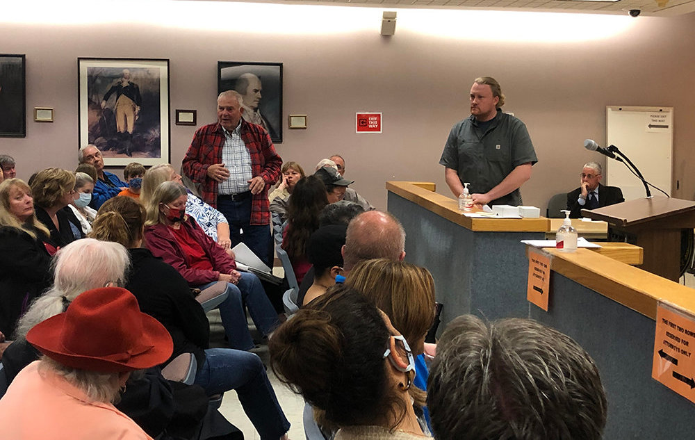 Robert Minard, (standing left) owner of the property speaks in support of the proposed project by Blooming Hill Farm at a June meeting.