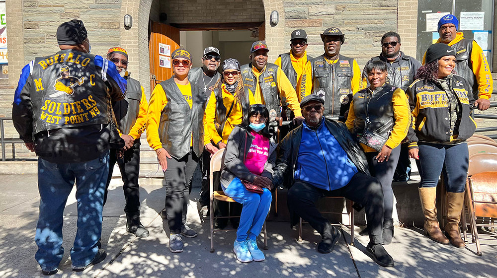 Calvary Pastor J. Edward Lewis [center in blue] joins together with the Buffalo Soldiers to celebrate the fire prevention fair’s success and Calvary Church.
