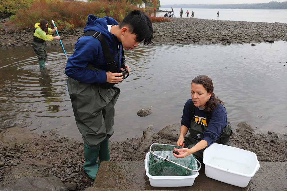 Highland Middle School Grade 8 student Nathan Zheng checks out his “catch” along with Science teacher Cornelia Harris.