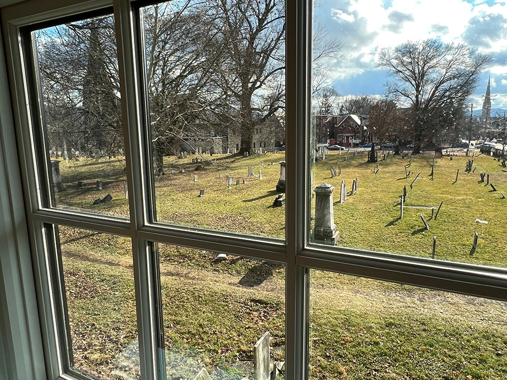 A view of the Old Town Cemetery from the second floor of the tavern through modern windows.