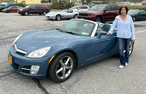 Donna Horneman stands next to her 2007 Saturn Sky convertible.