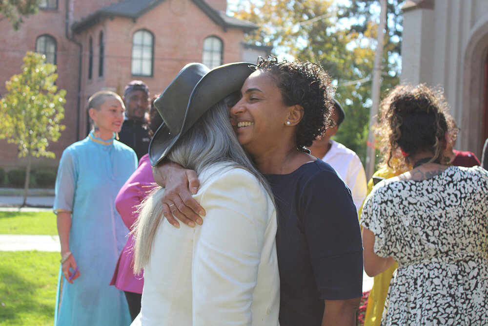 (L-R) Melanie Collins and Angela Paul-Gaito share an embrace to mark the grand opening of Highpoint campus.