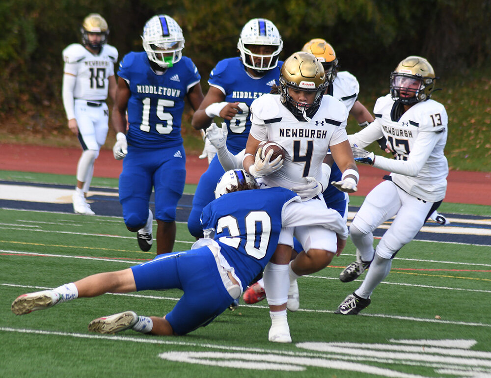 Newburgh's Tajir Walker tries to run through the tackle of Middletown's Joe Mann during Saturday's Section 9 Class AA championship football game at Academy Field in Newburgh.