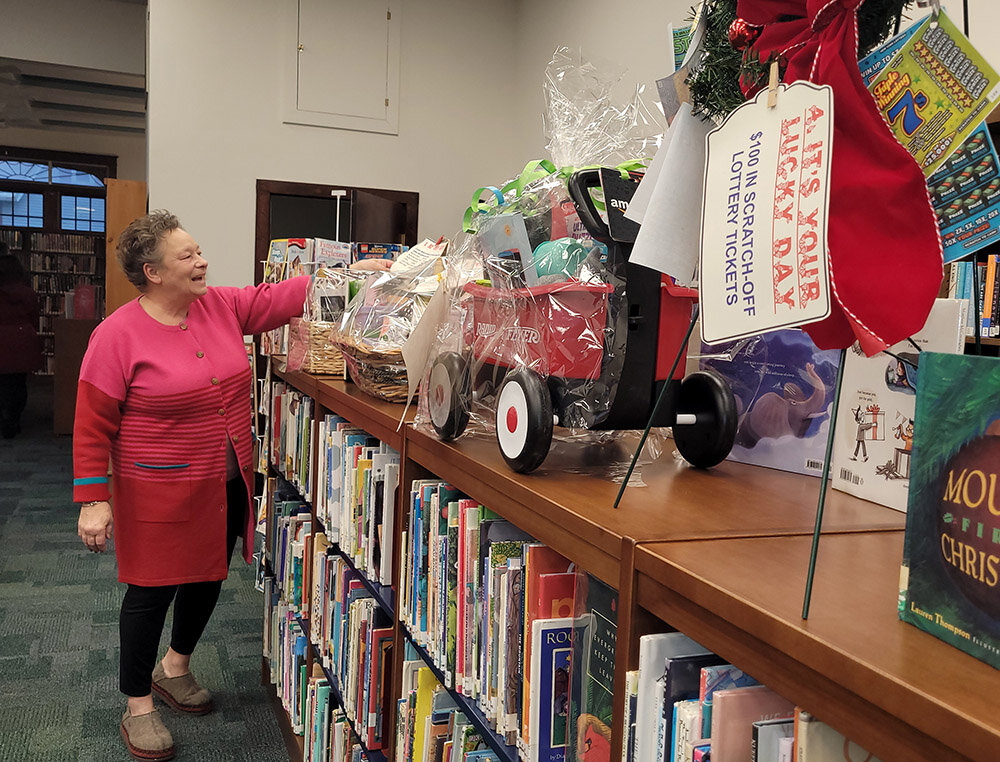 Maribeth Wooldridge-King shows off an assortment of gift baskets available through a special raffle December 3. The raffle took place in concert with the annual Milton tree-lighting ceremony.