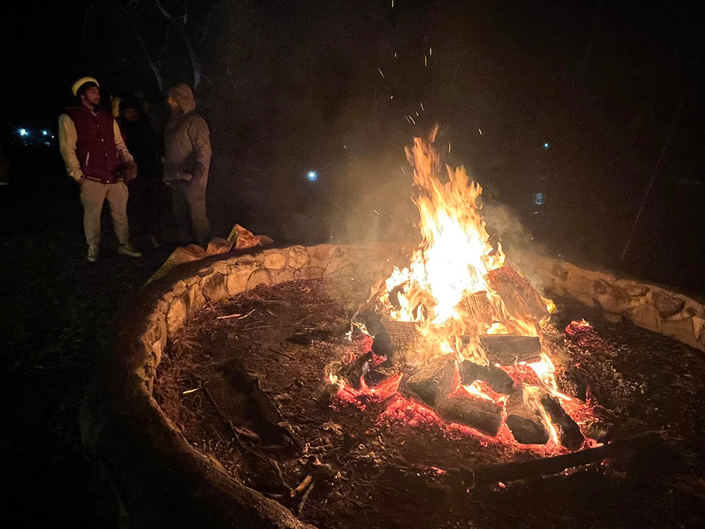 The annual fire keeps visitors warm during a rainy and brisk holiday celebration.