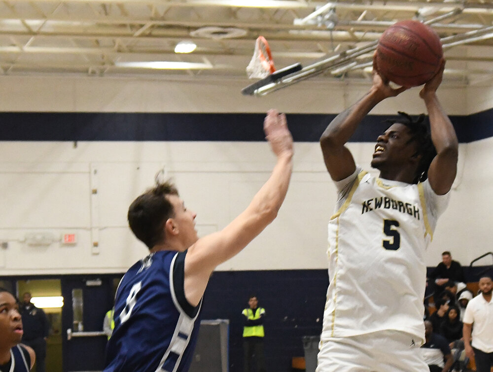Newburgh’s Elnathan Johnson shoots over Mekeel Christian’s Caleb Hussey during Saturday’s non-league boys’ basketball game at Newburgh Free Academy.